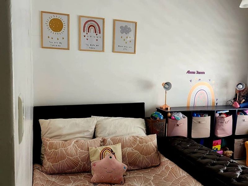 A bedroom featuring neutral wall finishes and standard lighting, suitable for a child's room or guest space.