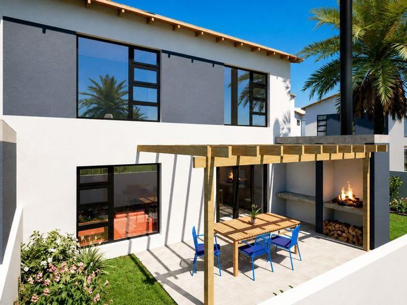 Rear exterior view of a modern townhouse featuring a tiled patio with a timber pergola and a built-in braai area overlooking a private garden.
