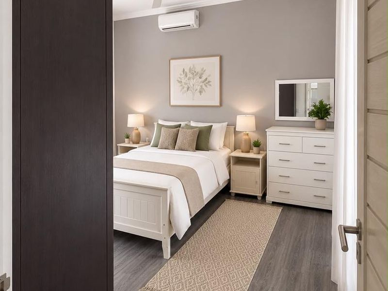 A well-maintained bedroom featuring modern laminate flooring, a ceiling fan, and a wall-mounted split-system air conditioner.