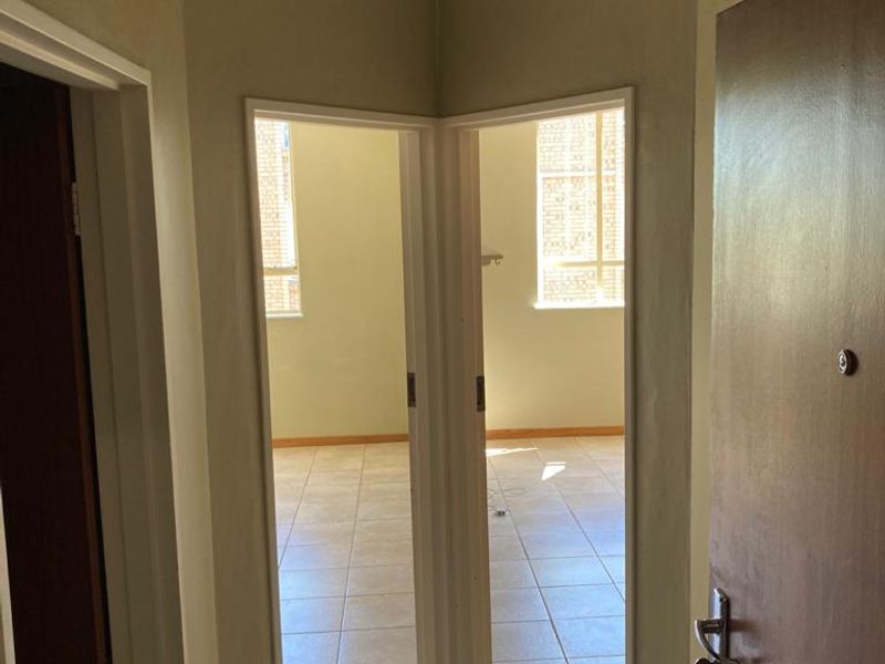 A functional hallway with tiled flooring providing access to adjacent rooms, featuring neutral wall tones and standard internal door frames.
