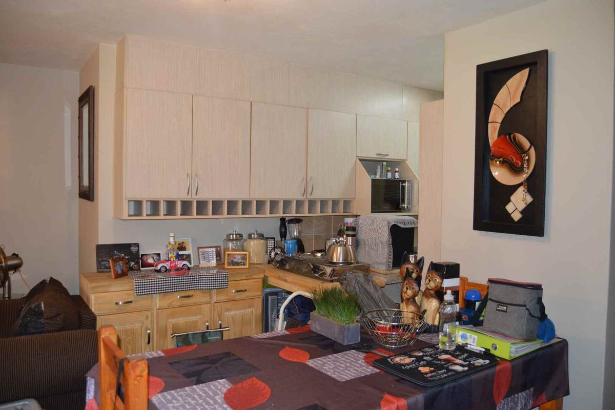 A functional kitchen area featuring light wood-toned cabinetry and ample storage space, suitable for updating with modern finishes.