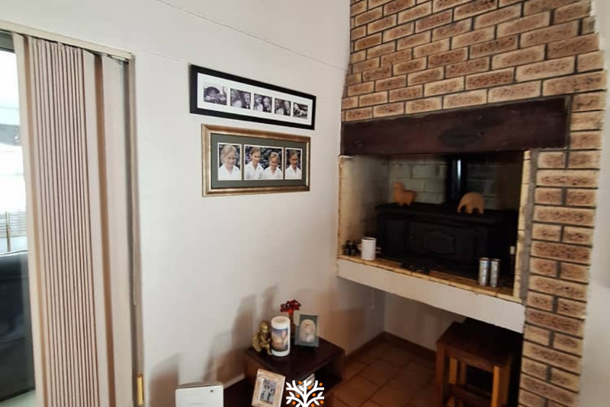 Living area featuring a prominent brick fireplace with an integrated wood-burning stove and tiled flooring.