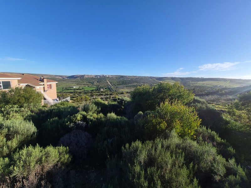 A scenic view overlooking the natural landscape and surrounding terrain, showcasing the expansive outdoor environment of the residential land.