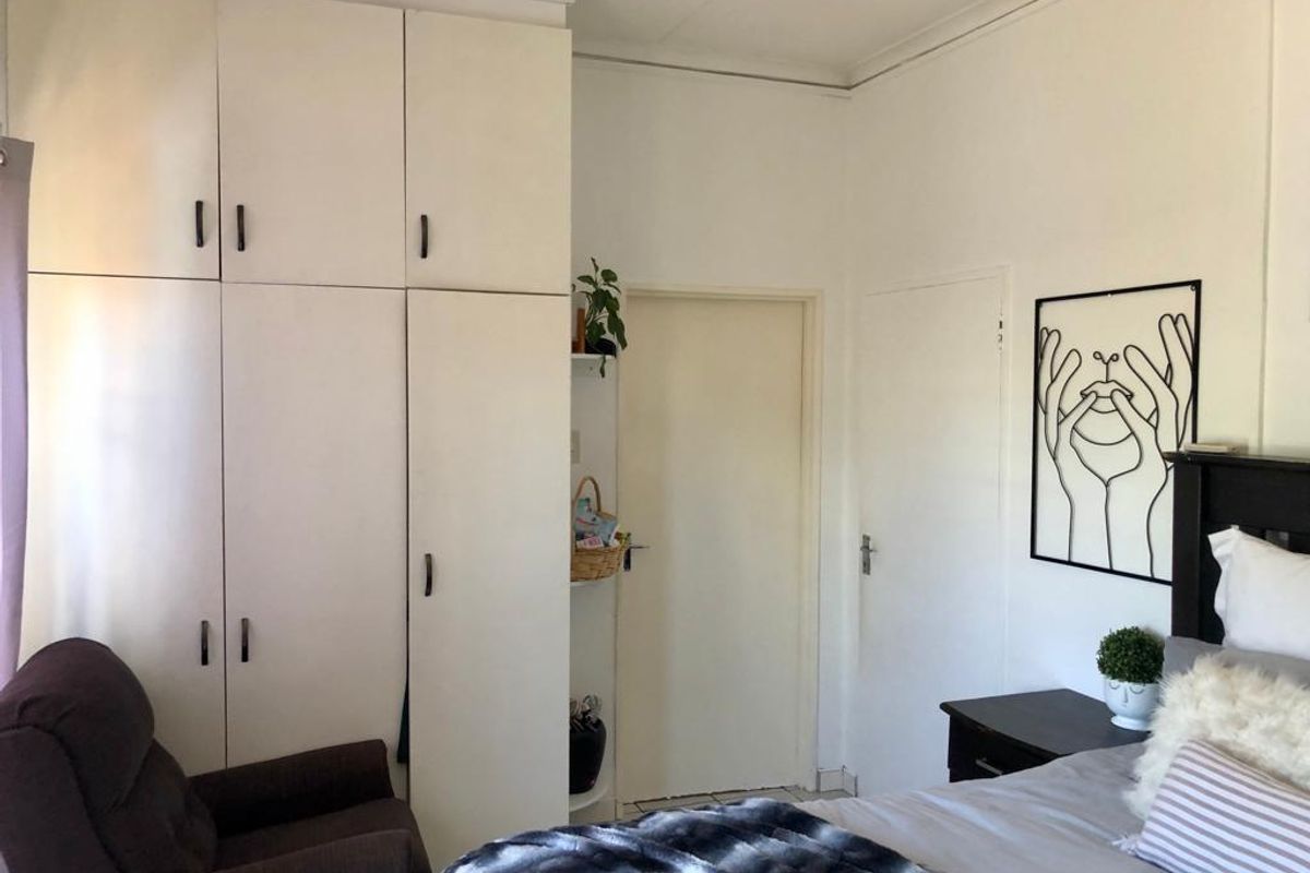 A bedroom featuring floor-to-ceiling built-in cupboards and neutral wall finishes, providing functional storage space.