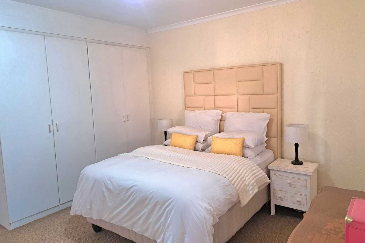 A bedroom featuring built-in cupboards and neutral carpeting, providing a functional and comfortable living space.