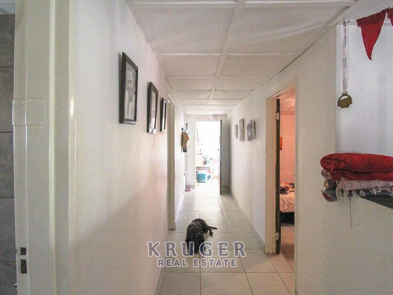 A functional hallway featuring tiled flooring and a drop ceiling, providing access to various rooms within the home.