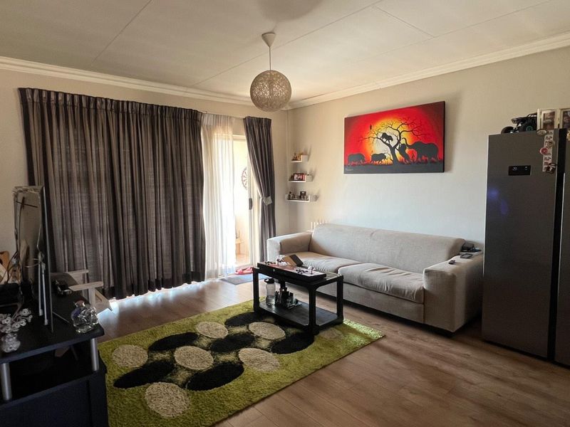 A comfortable living room featuring laminate flooring and a sliding glass door providing access to an outdoor area.