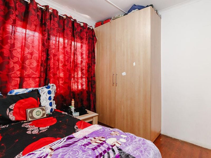 A bedroom featuring a built-in wardrobe and wooden flooring, providing functional storage space within the office property.