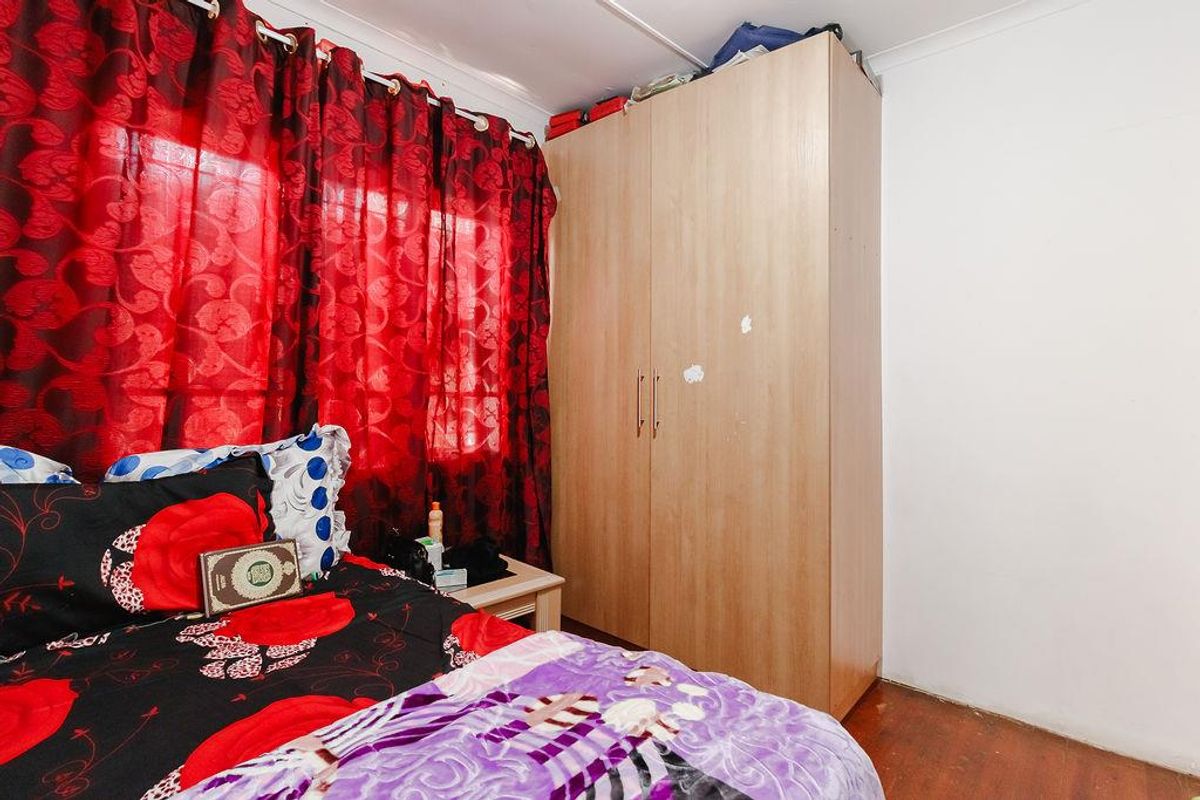A bedroom featuring a built-in wardrobe and wooden flooring, providing functional storage space within the office property.