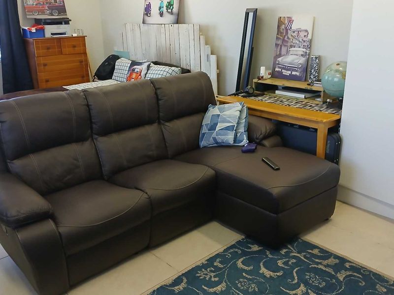 A living room area featuring tiled flooring and a built-in wardrobe, providing a functional space for relaxation.