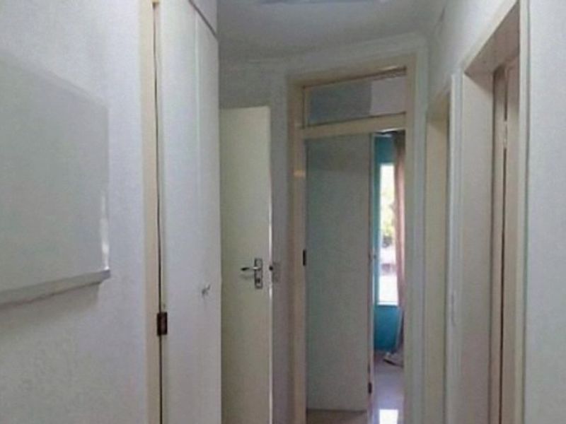A functional interior hallway featuring built-in storage cupboards and access to adjacent rooms.