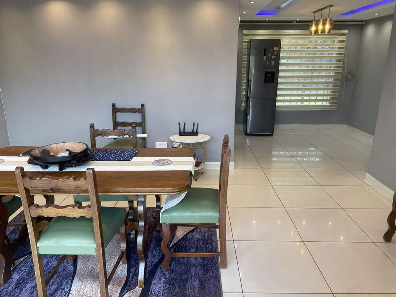 Open plan living and dining area featuring polished porcelain floor tiles, recessed ceiling lighting, and modern window blinds.