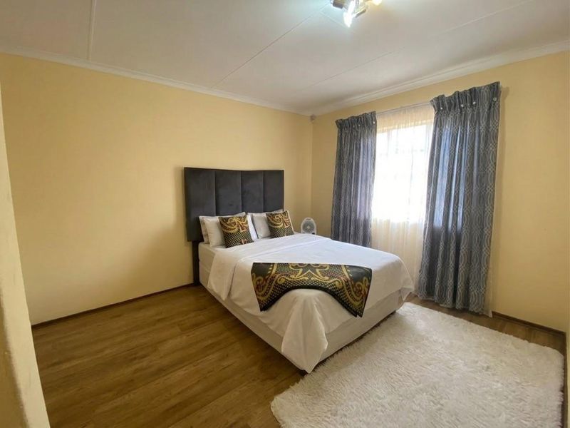 A standard bedroom featuring laminate flooring and coved ceilings, providing a functional and neutral space ready for personalization.