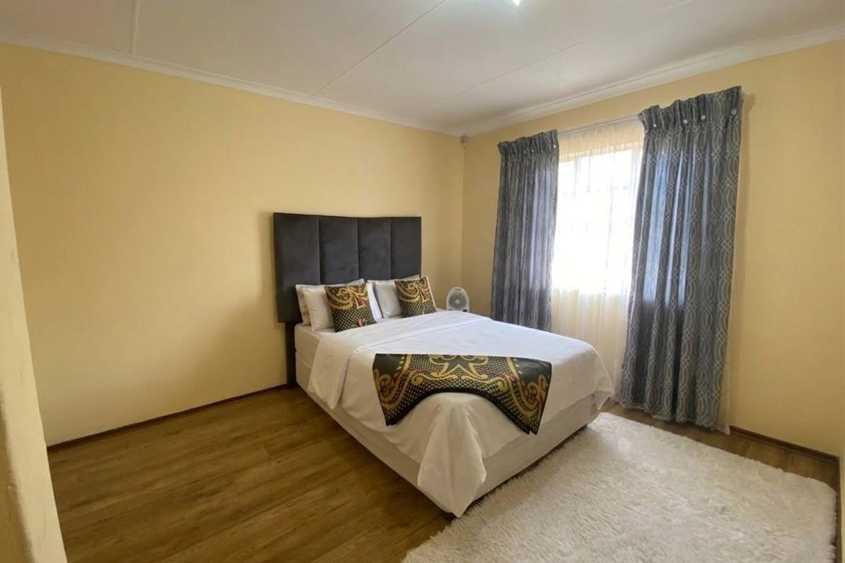 A standard bedroom featuring laminate flooring and coved ceilings, providing a functional and neutral space ready for personalization.