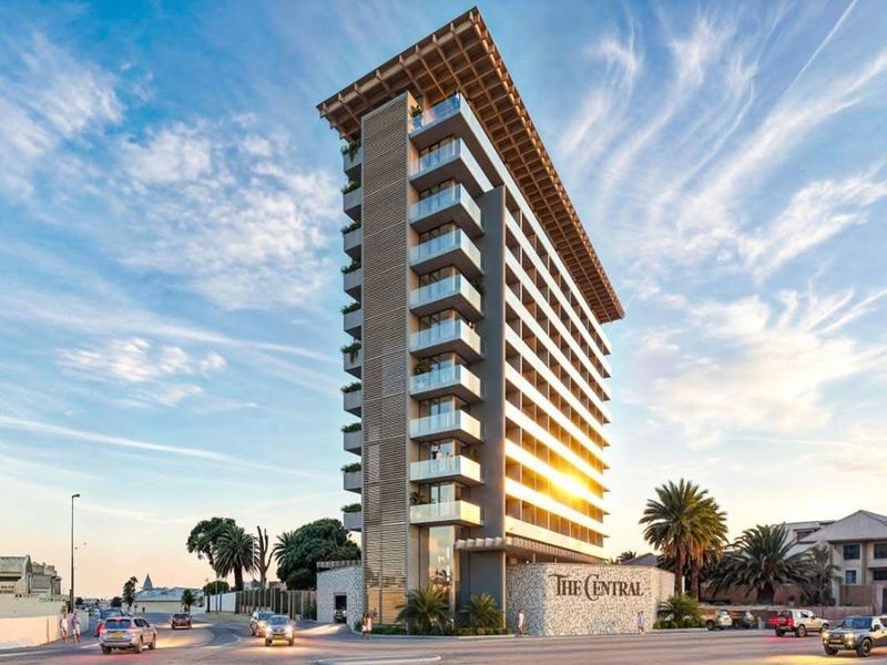 Modern high-rise hotel building featuring contemporary architectural design, glass balconies, and stone-clad entrance signage.