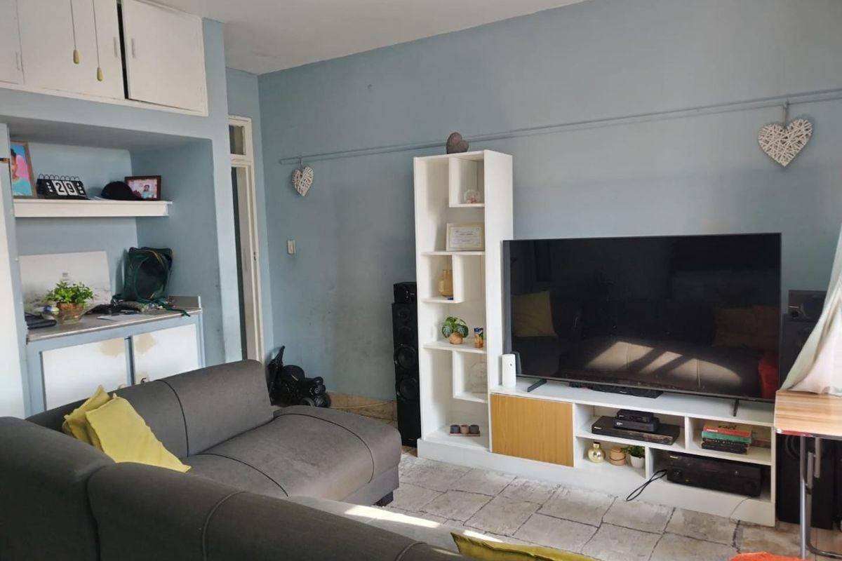 A living room featuring built-in cabinetry and alcove shelving, offering potential for a refreshed layout and updated finishes.