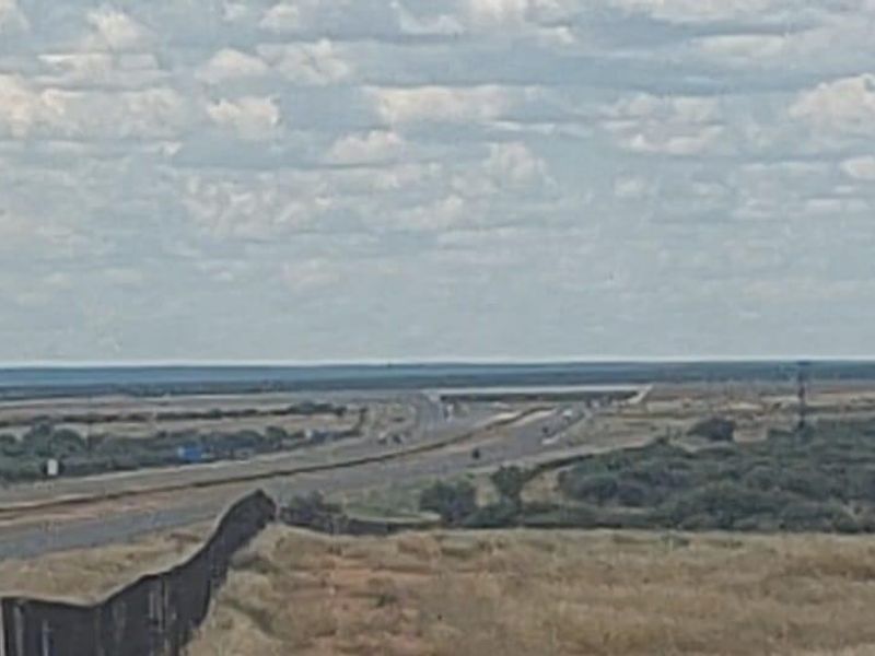 A wide-angle view of the surrounding landscape featuring a nearby highway and open agricultural land.
