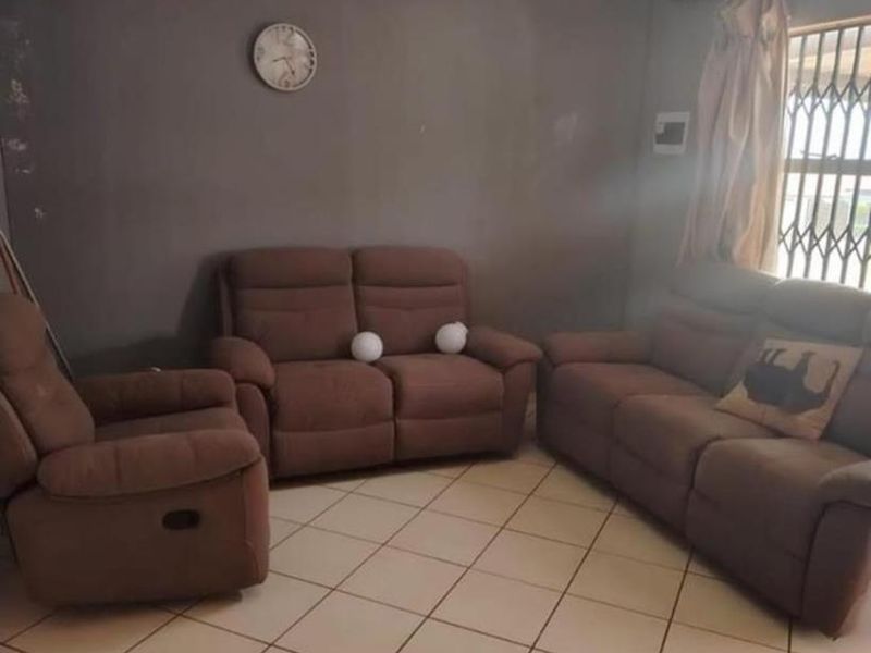 A living room featuring tiled flooring and a window with a security gate, providing a functional space for relaxation.