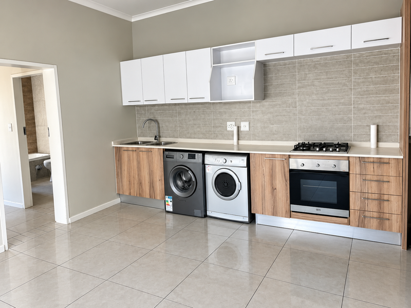 Modern kitchen featuring wood-finish cabinetry, stainless steel appliances, gas hob, built-in oven, and neutral tiled flooring with an adjacent bathroom view.