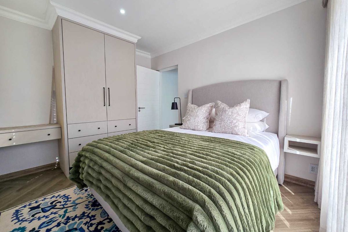 A well-maintained bedroom featuring built-in cabinetry, recessed ceiling lighting, and modern wood-look flooring, offering a clean and contemporary living space.