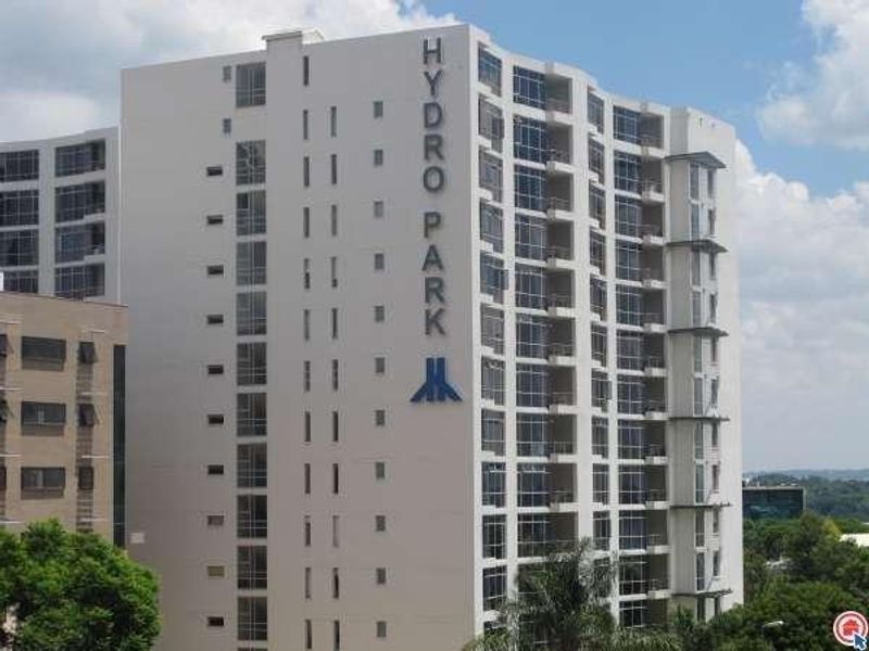 Exterior view of the Hydro Park apartment building, showcasing its modern facade, numerous balconies, and large glass windows.