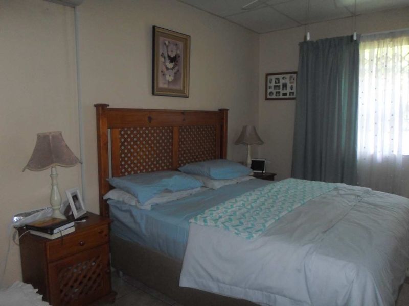 A standard bedroom featuring tiled flooring and window treatments, offering a functional space ready for personalization.