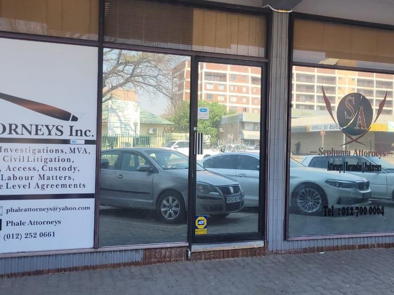 Commercial storefront entrance featuring large glass panels with professional signage and aluminum framing.