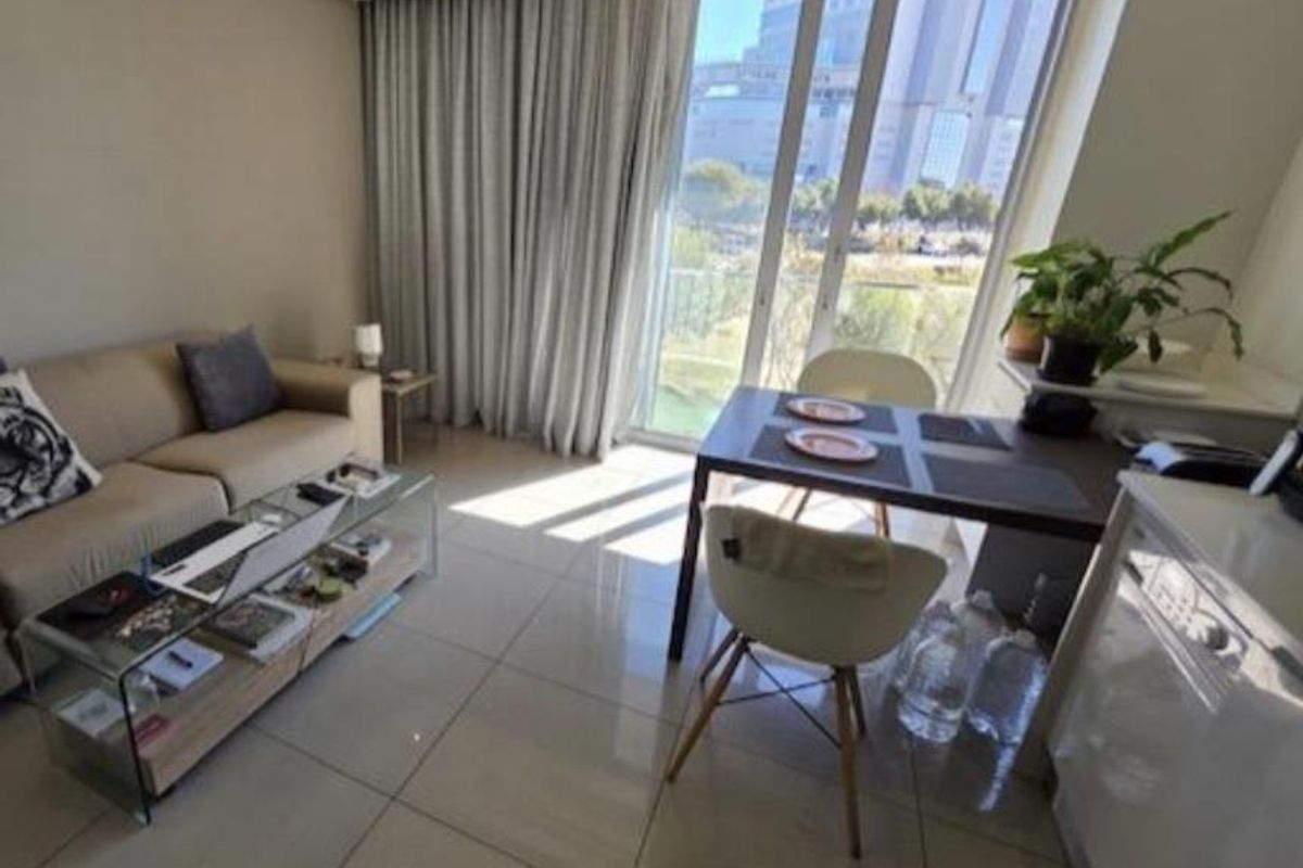 Modern open-plan living and dining area featuring large floor-to-ceiling glass doors, tiled flooring, and integrated ducted air conditioning.