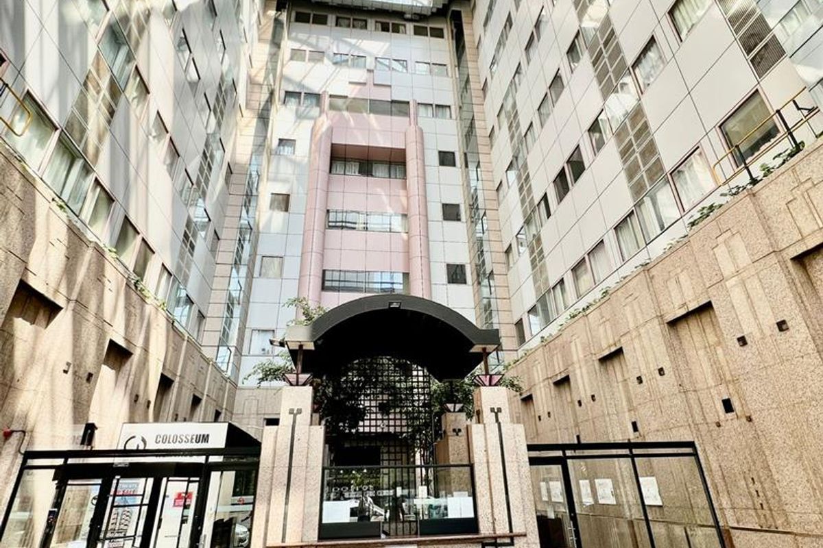 A view of the building's central atrium featuring a glass roof, stone facade, and secure entrance area.