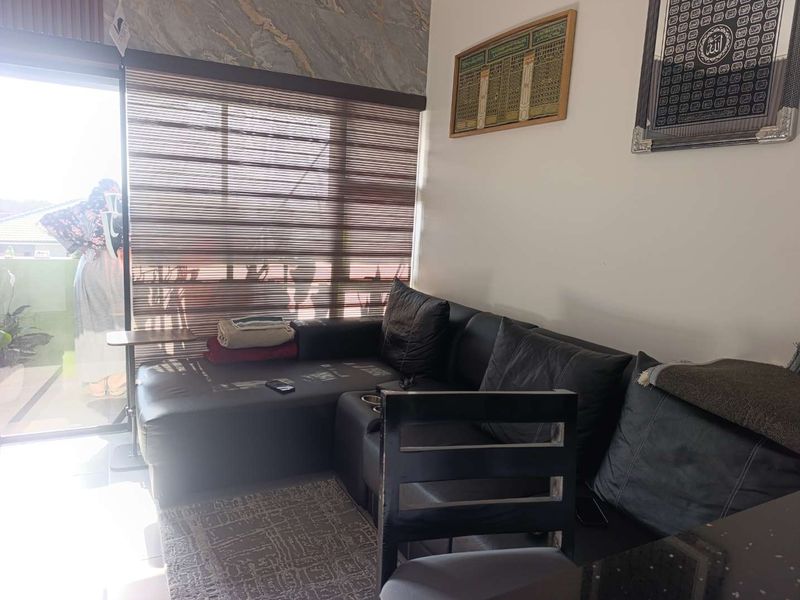 A living room area featuring a sliding glass door with roller blinds and decorative marble-effect wall cladding.