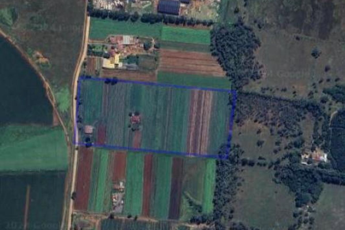 Aerial view of the farm property showing the land layout, agricultural fields, and existing structures within the highlighted boundary.