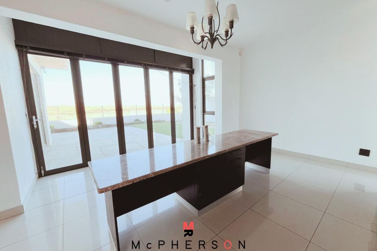 Spacious living area featuring large glass sliding doors leading to the patio, tiled flooring, and a built-in granite-topped counter.