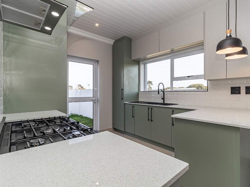 Modern kitchen featuring sage green cabinetry, quartz countertops, subway tile backsplash, gas hob with extractor, and a tongue and groove ceiling.