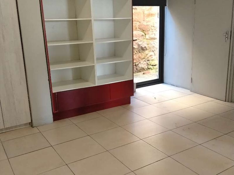 Office space featuring tiled flooring, a built-in shelving unit, and direct access to an outdoor area through a glass door.