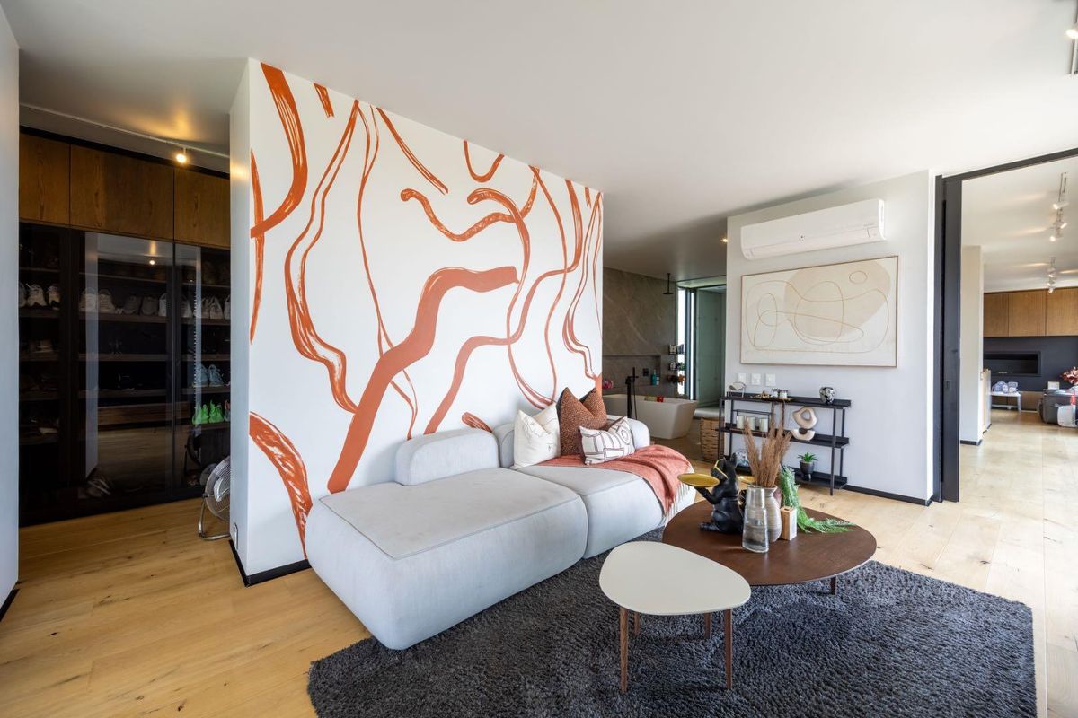 Modern bedroom suite featuring hardwood flooring, a built-in wardrobe, split-system air conditioning, and an open-plan layout with an integrated ensuite bathtub.