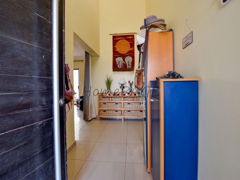 A bright entrance hall featuring high ceilings and neutral tiled flooring, providing a welcoming transition into the main living areas of the home.