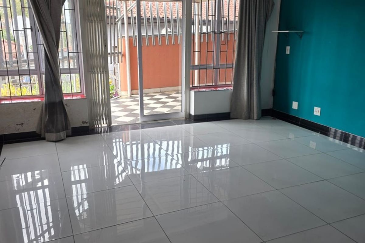 Spacious living area featuring polished porcelain floor tiles, recessed lighting, and direct access to an outdoor patio through sliding glass doors.