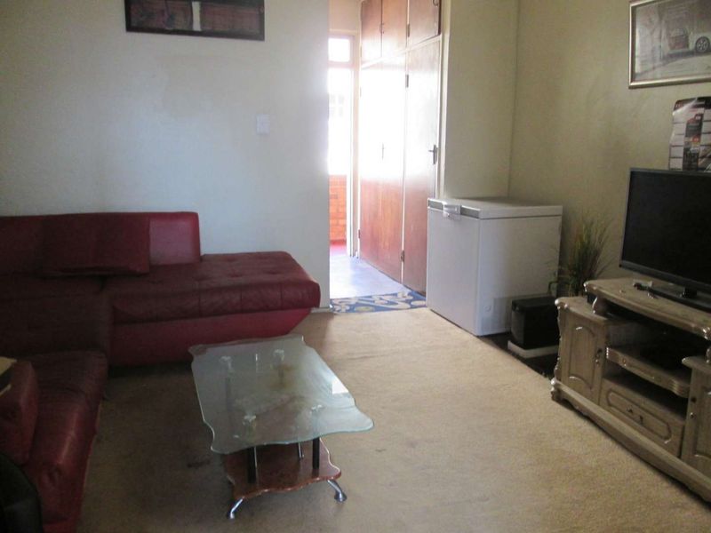 A living room area featuring built-in storage cupboards and access to an adjoining balcony space.