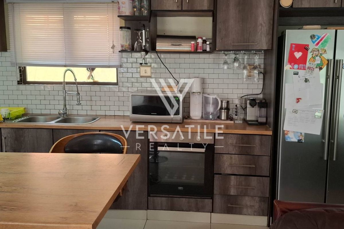 A functional kitchen featuring dark wood-look cabinetry, subway tile backsplash, integrated oven, and a double-basin sink with a modern faucet.