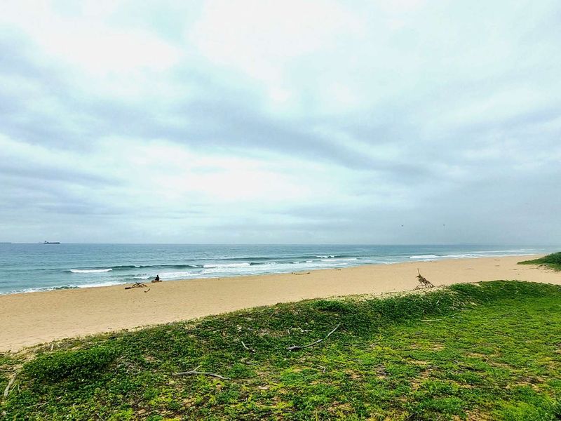 A scenic coastal view overlooking the sandy beach and ocean horizon.