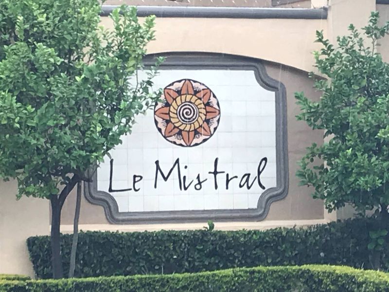 The entrance signage for the Le Mistral apartment complex, featuring decorative tiling and well-maintained landscaping.