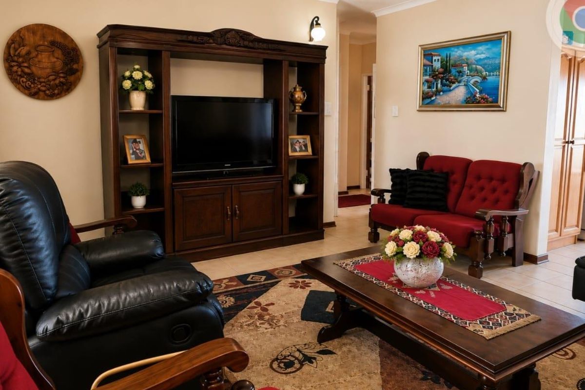 A comfortable living room featuring tiled flooring, coved ceilings, and a neutral wall palette, providing a functional and inviting space for relaxation.