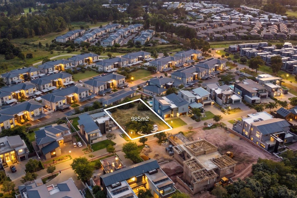 An aerial view of a 985m2 vacant residential plot situated within a developed estate, highlighting the available land and surrounding neighborhood context.