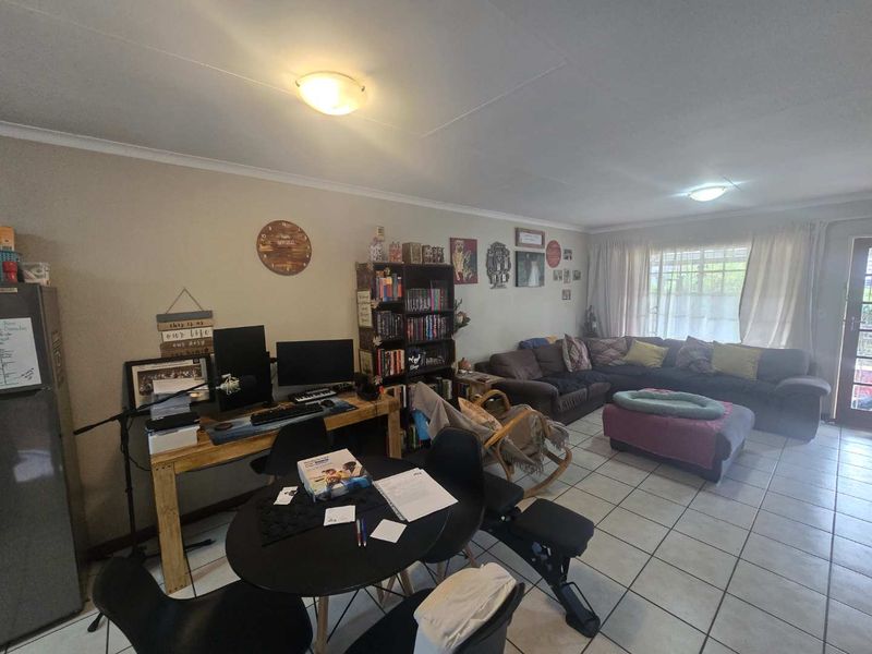 Open plan living area featuring tiled flooring and a sliding glass door providing access to the exterior.