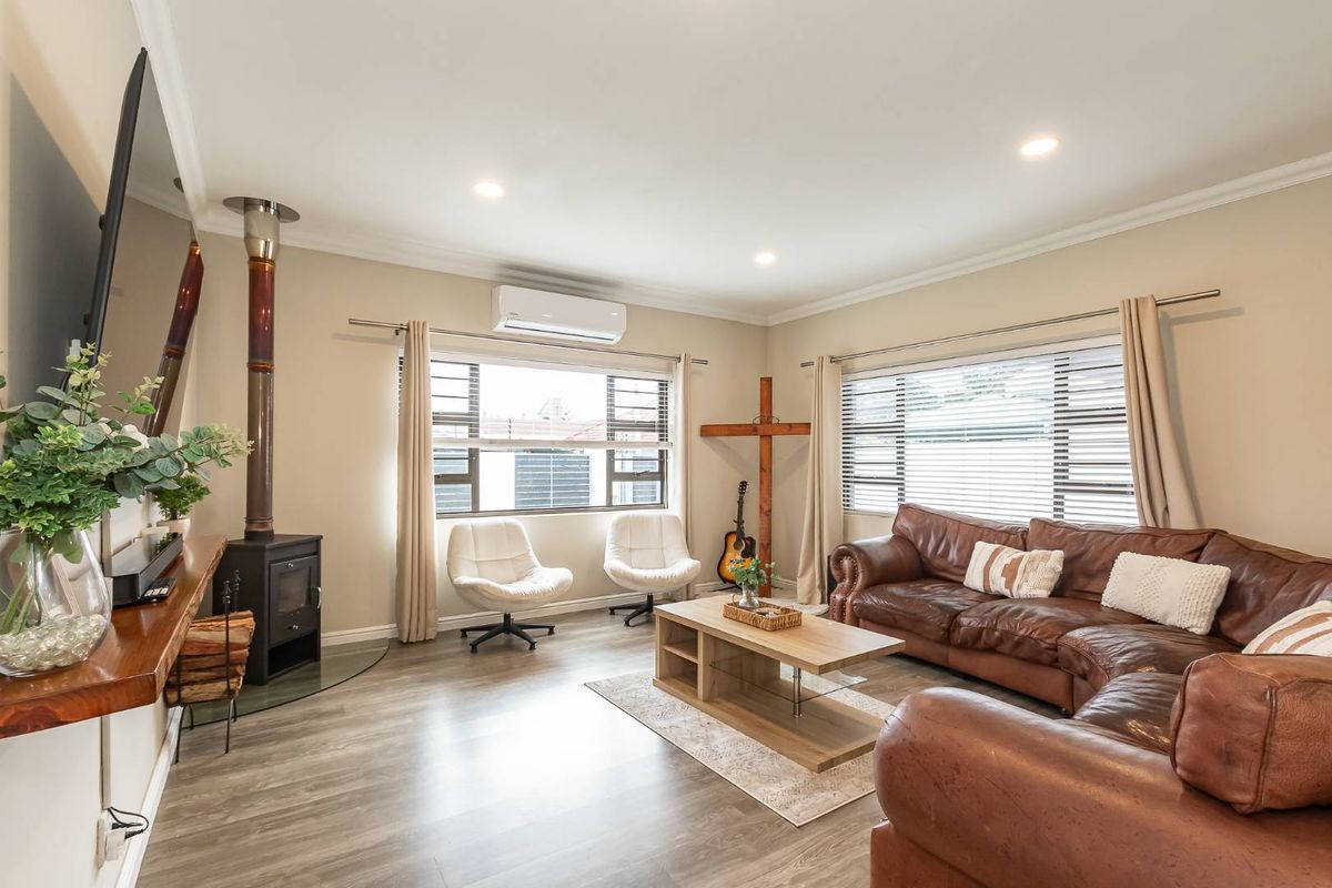 Spacious living room featuring wood-look flooring, recessed lighting, a built-in fireplace, and a wall-mounted air conditioning unit.