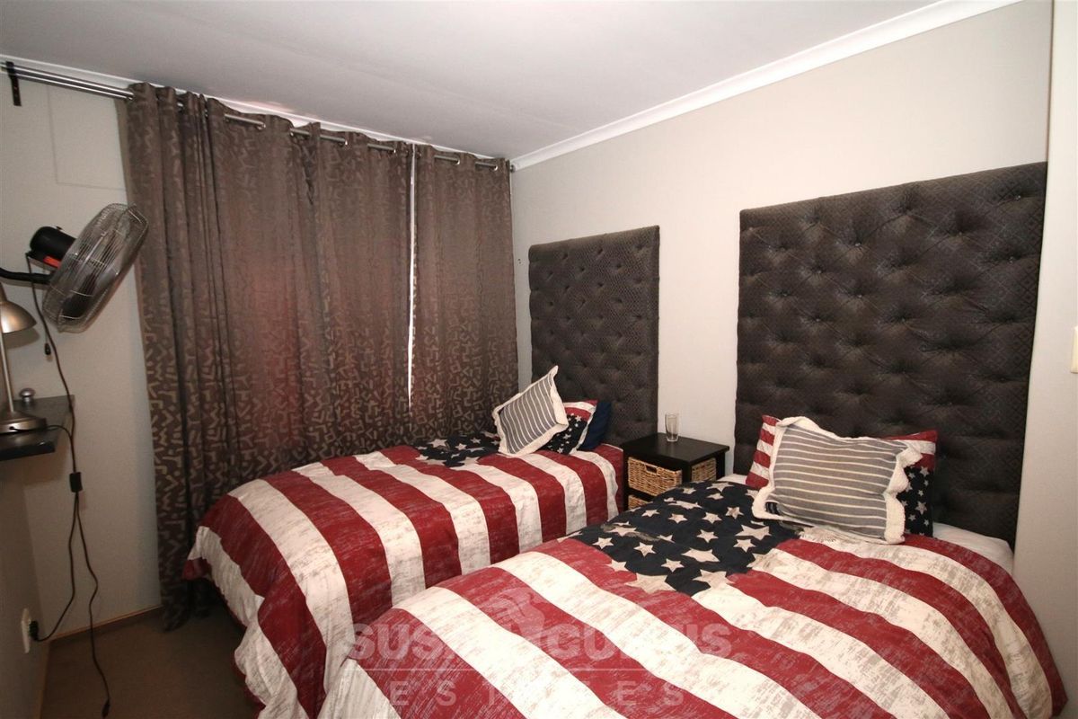 A bedroom featuring neutral walls, carpeted flooring, and built-in curtain tracks.