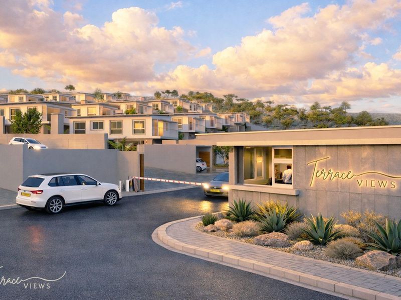 A modern residential estate entrance featuring a security gatehouse, boom gate access, and landscaped surroundings at the Terrace Views townhouse development.