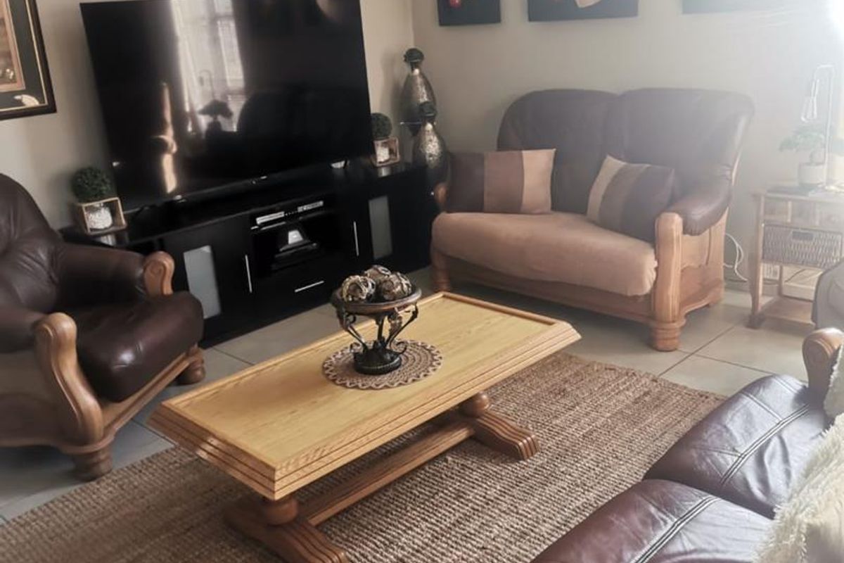A comfortable living room featuring tiled flooring and neutral wall tones, providing a functional space for relaxation and entertainment.
