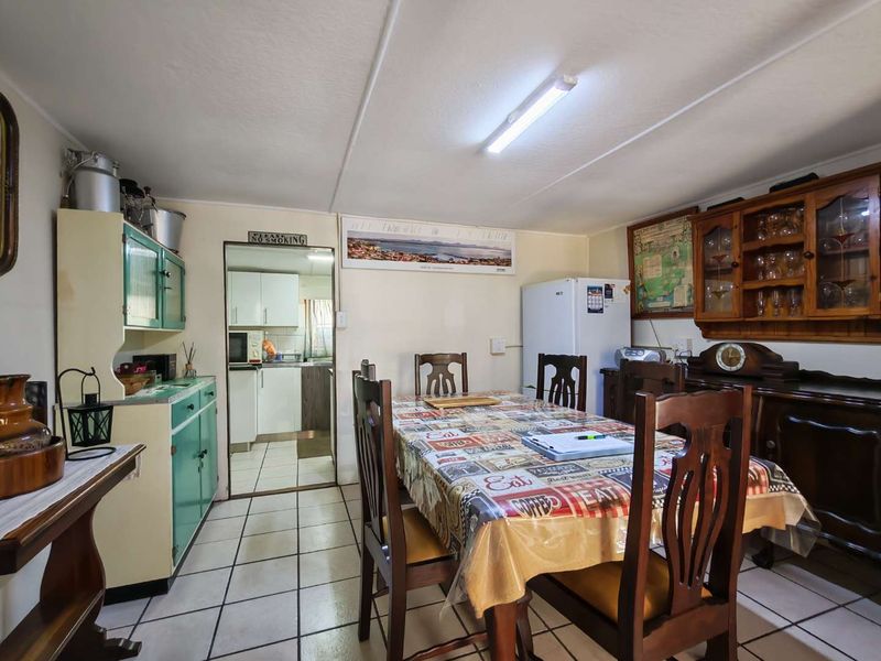 A dining area featuring tiled flooring and built-in cabinetry, with an adjacent view into the kitchen space.