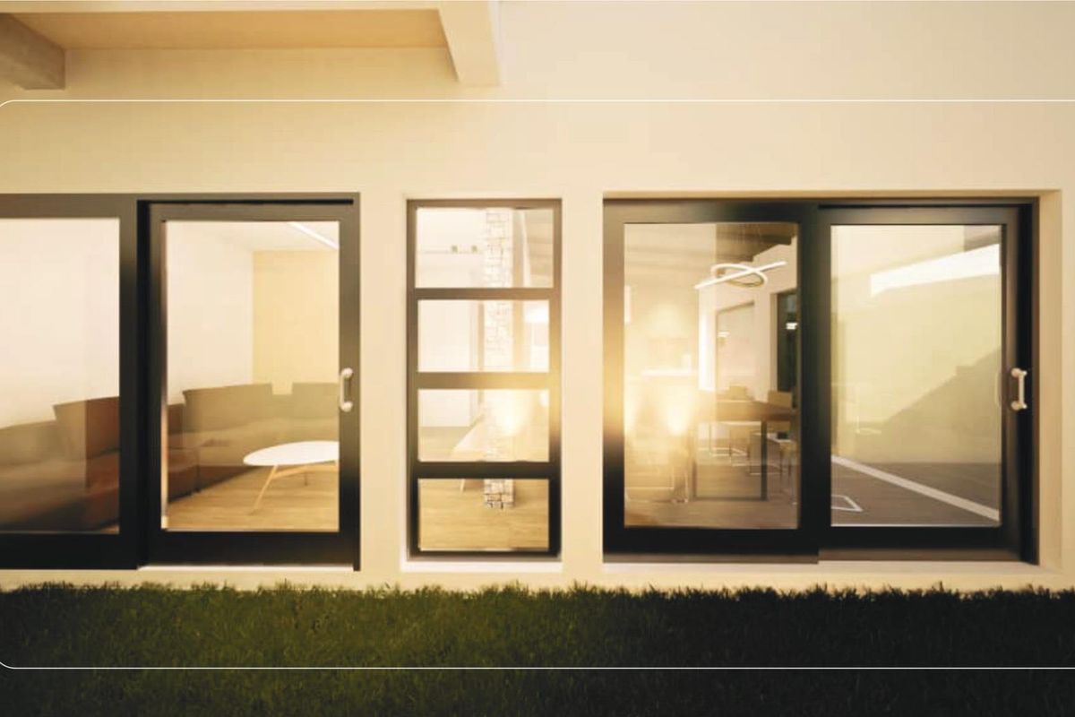 Rear exterior view of a townhouse featuring modern black-framed sliding glass doors and a central fixed glass panel.
